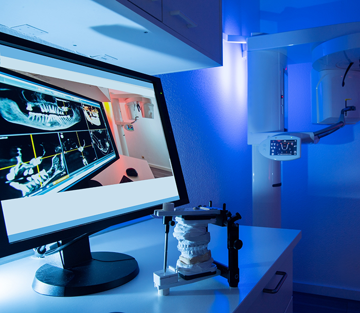 Computer monitor showing multiple scans and x rays of a patients teeth