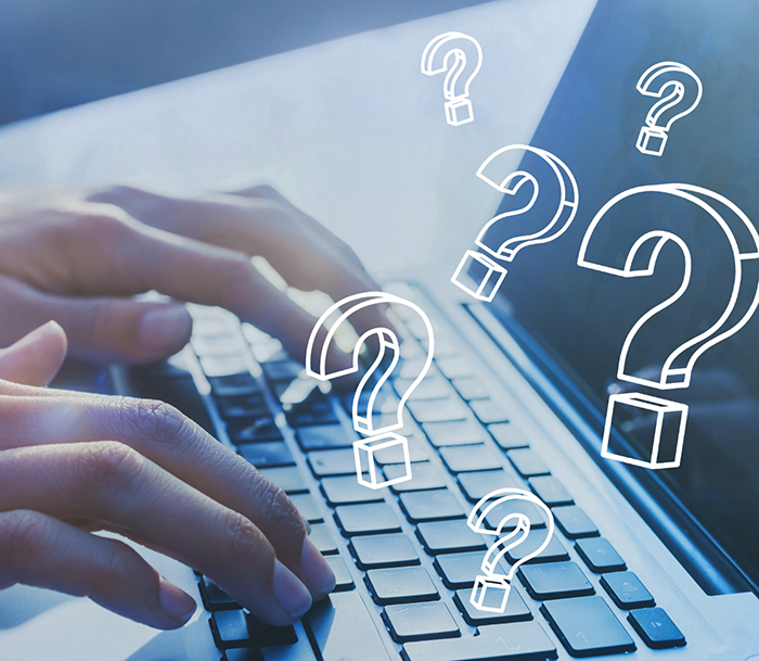 Close up of hands typing on a laptop with illustrations of question marks