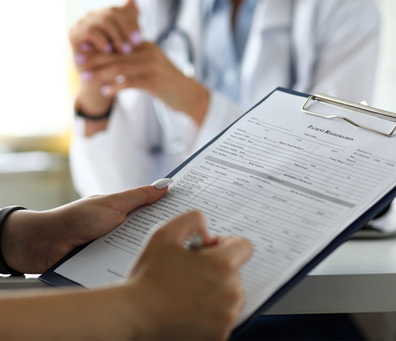 Dental patient filling out paperwork on a clipboard
