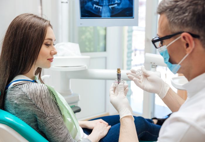 Endodontist in Bloomfield showing a dental implant to a patient