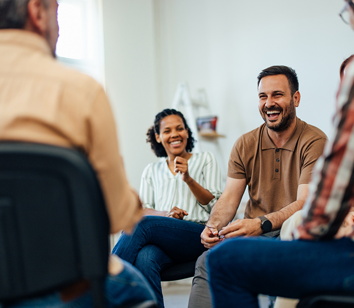 Group of adults sitting in a circle and laughing together