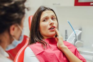 Patient looking apprehensive in dentist's chair.